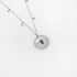 White gold round pendant with mother of pearl, diamonds and a center sapphire